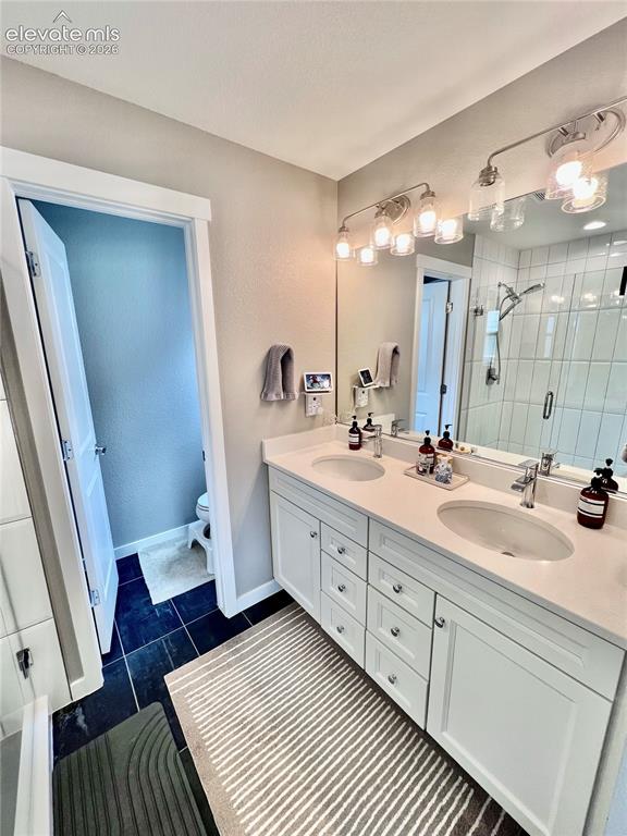 Image 11 of 20: Bathroom vanity with dual undermount sinks, quartz countertops, and white s
