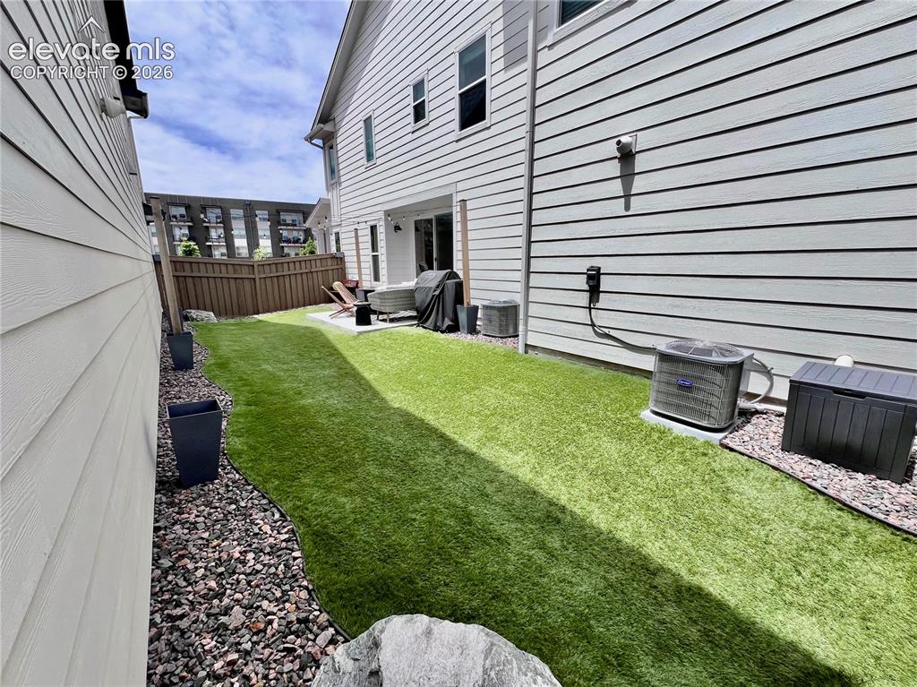 Image 17 of 20: Manicured artificial turf lawn with a curved gravel border