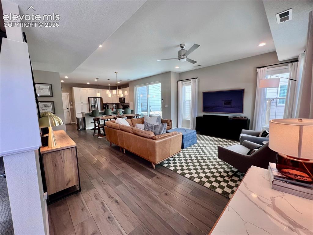 Image 3 of 20: Open-concept living area featuring wood-finish flooring, recessed lighting,