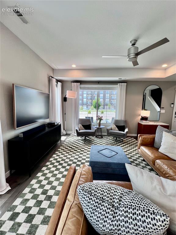 Image 4 of 20: Living area featuring wood-finish flooring with a checkered area rug