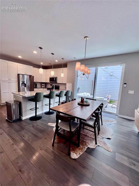 Image 5 of 20: Open-concept living space featuring wood-finish flooring, white cabinetry,