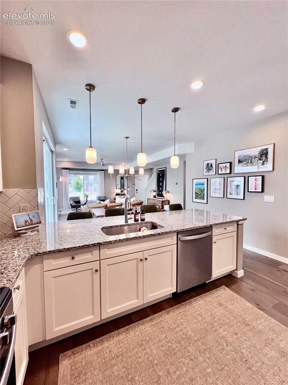 Image 8 of 20: Kitchen island featuring granite countertops, a double basin sink with a go