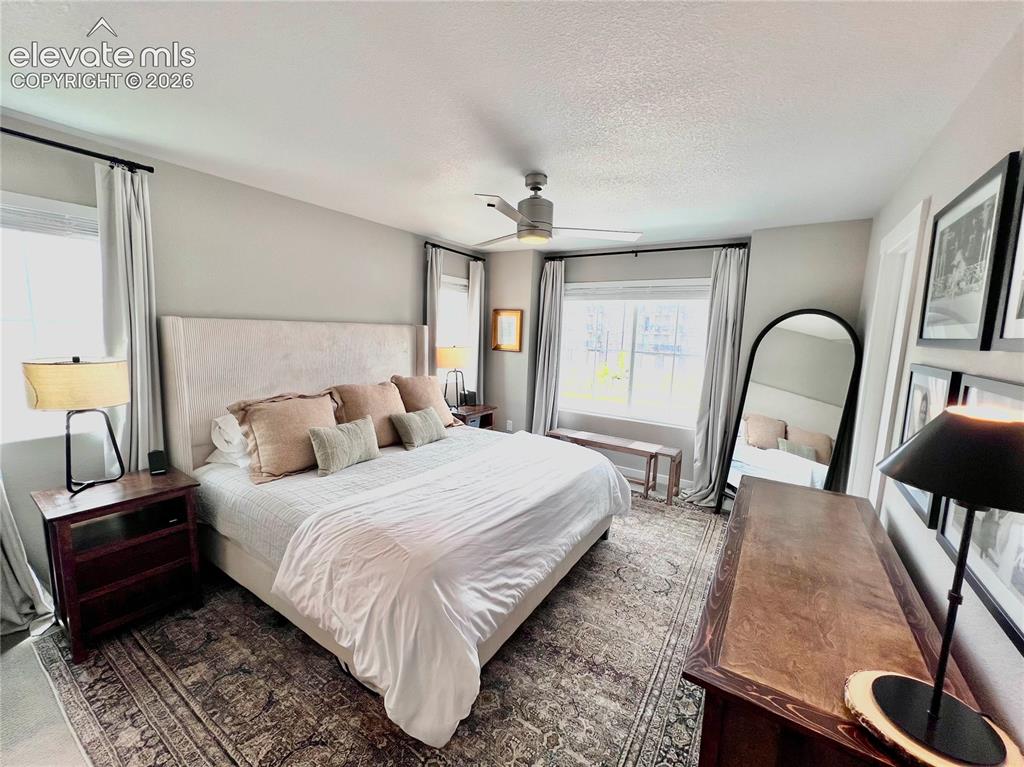 Image 9 of 20: Spacious room featuring light-toned walls, multiple windows with drapes, a