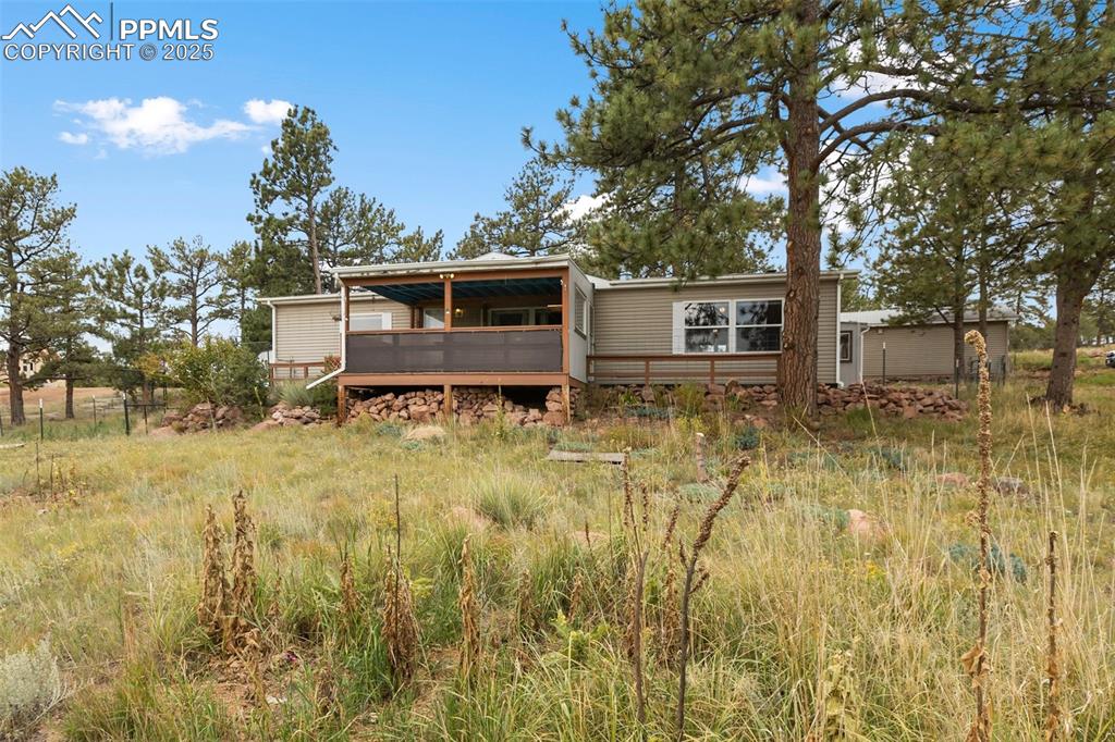Caption: Front view of house featuring a wooden deck