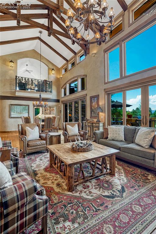 Image 20 of 50: Living area featuring a chandelier, healthy amount of natural light, beamed
