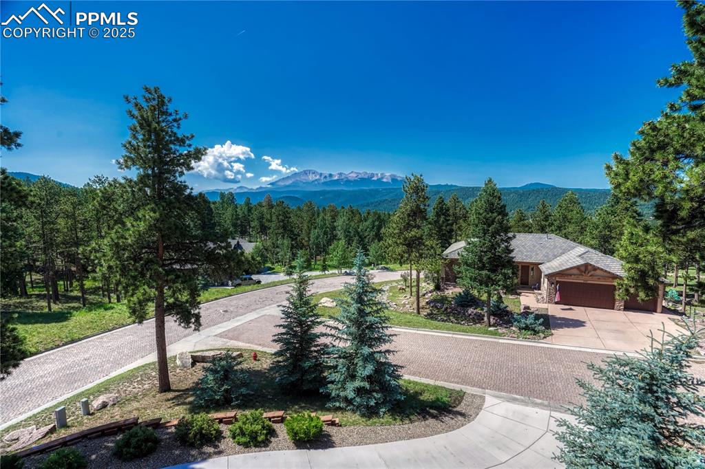 Image 50 of 50: Surrounding community featuring a mountain view, curved driveway, and an at