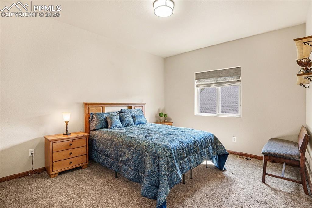 Image 19 of 35: The upstairs 1st bedroom offers comfort and convenience, featuring plush ca