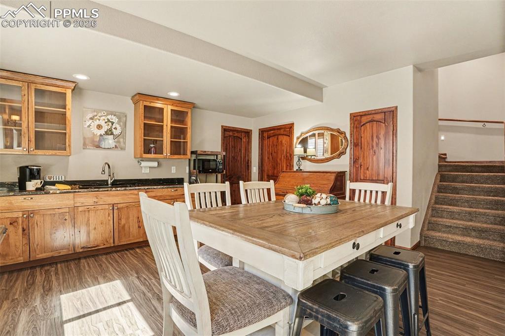 Image 25 of 35: The expansive basement living room includes a fully equipped wet bar with a