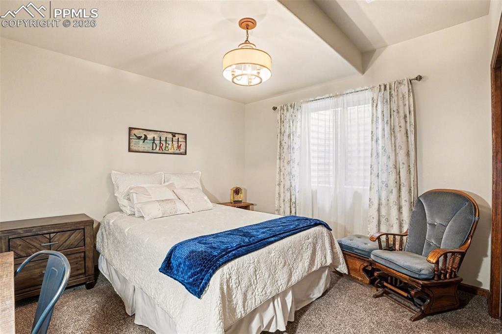 Image 27 of 35: The second basement bedroom is equally spacious and inviting, offering a pr