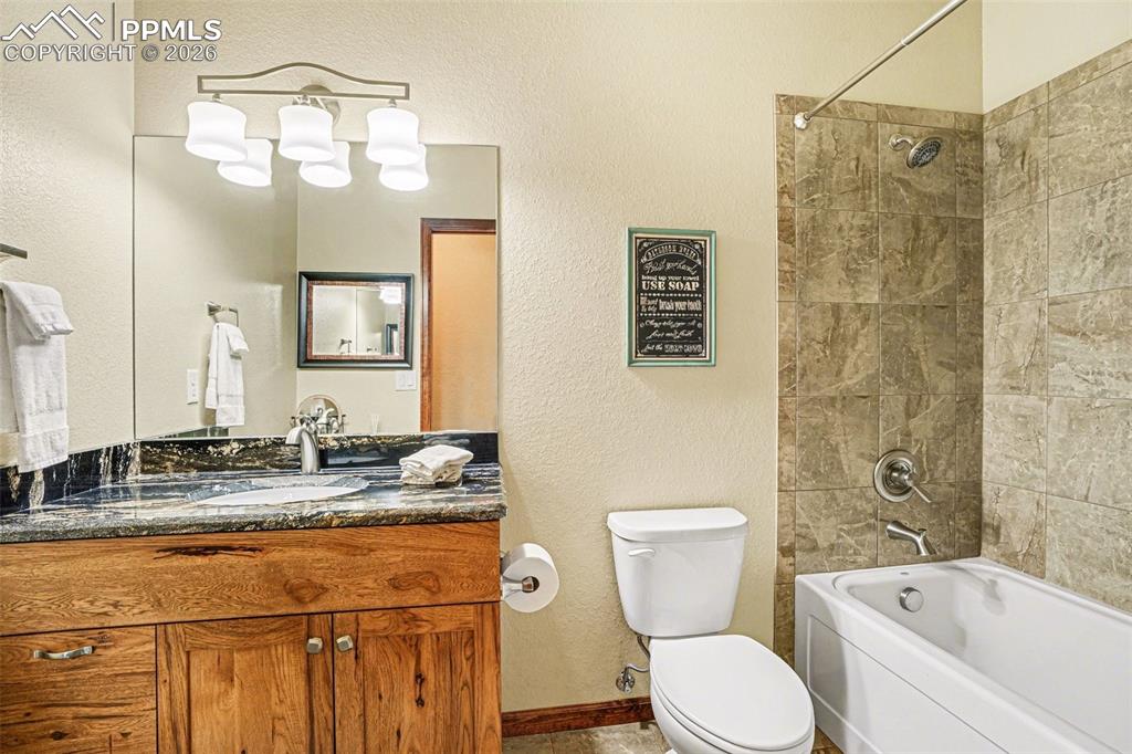 Image 28 of 35: The full bathroom in the basement is a luxurious retreat, featuring an over
