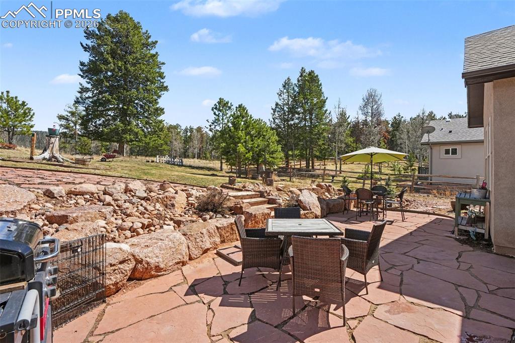 Image 30 of 35: The backyard features a charming slate patio, providing a perfect spot for 