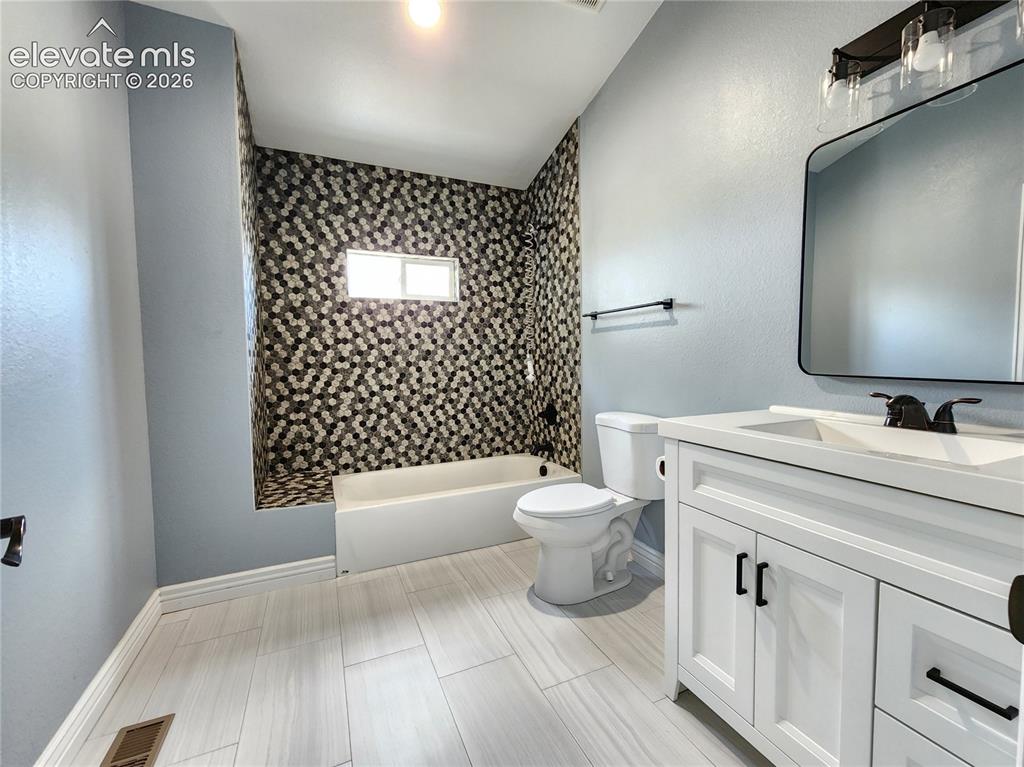 Image 25 of 49: Extra large pristine full bathroom complete with a modern vanity and update