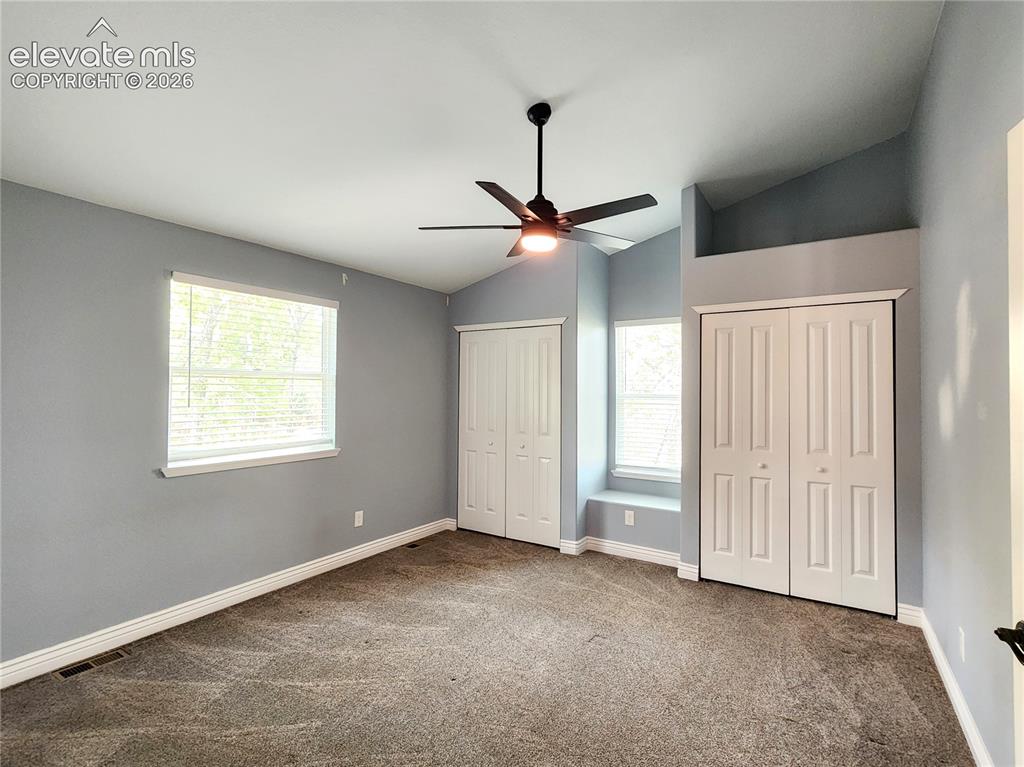 Image 27 of 49: Generously sized primary suite featuring plush carpeting and a ceiling fan
