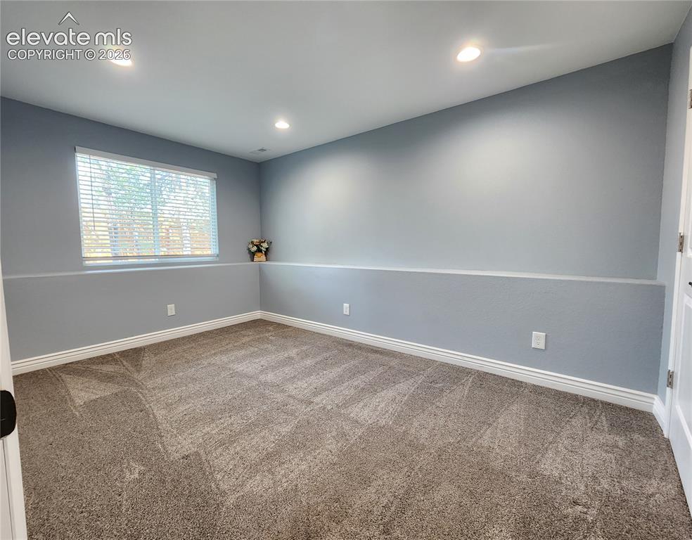 Image 32 of 49: Large lower-level bedroom featuring plush carpeting