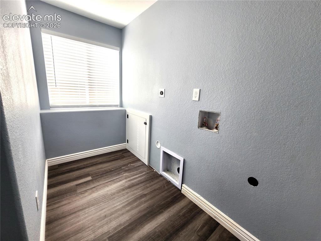 Image 39 of 49: Dedicated laundry room equipped with stylish wood-look flooring
