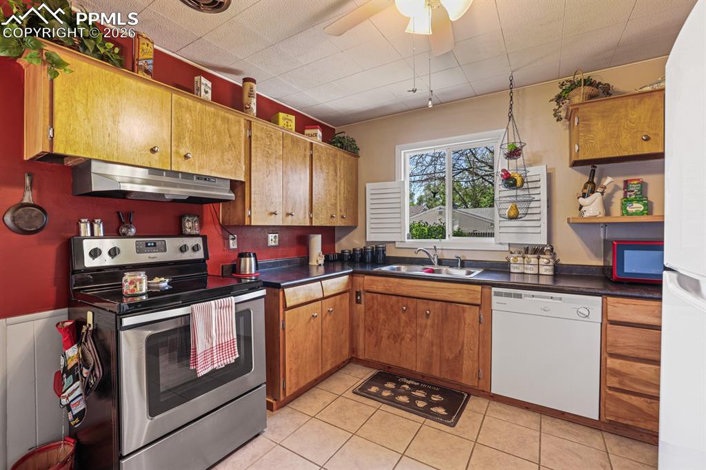Image 10 of 27: The Kitchen features ceramic tile floors, a lighted ceiling fan, wood cabin