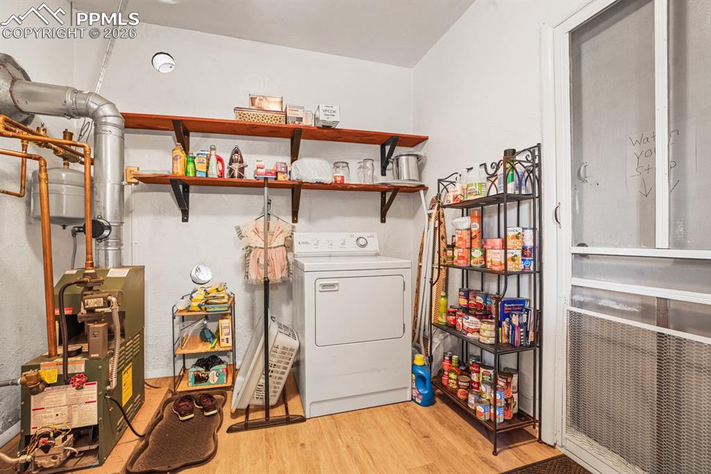 Image 13 of 27: The Laundry Room has built-in shelves, a walk out to the backyard, and wash
