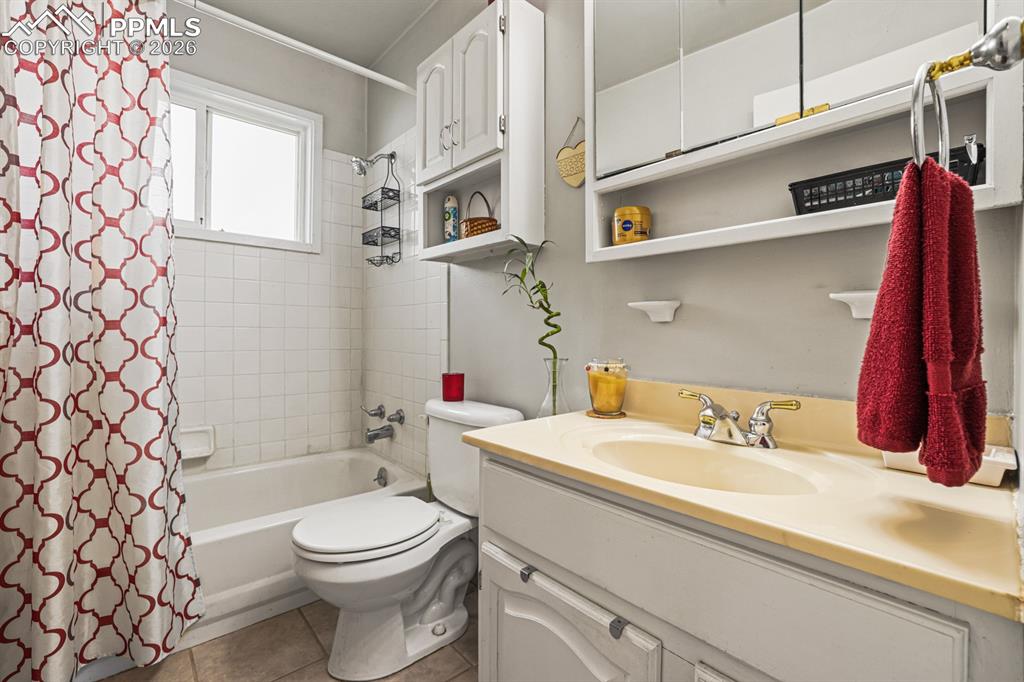 Image 16 of 27: Full Bathroom with vanity, mirrored medicine cabinet, and tiled tub/shower.