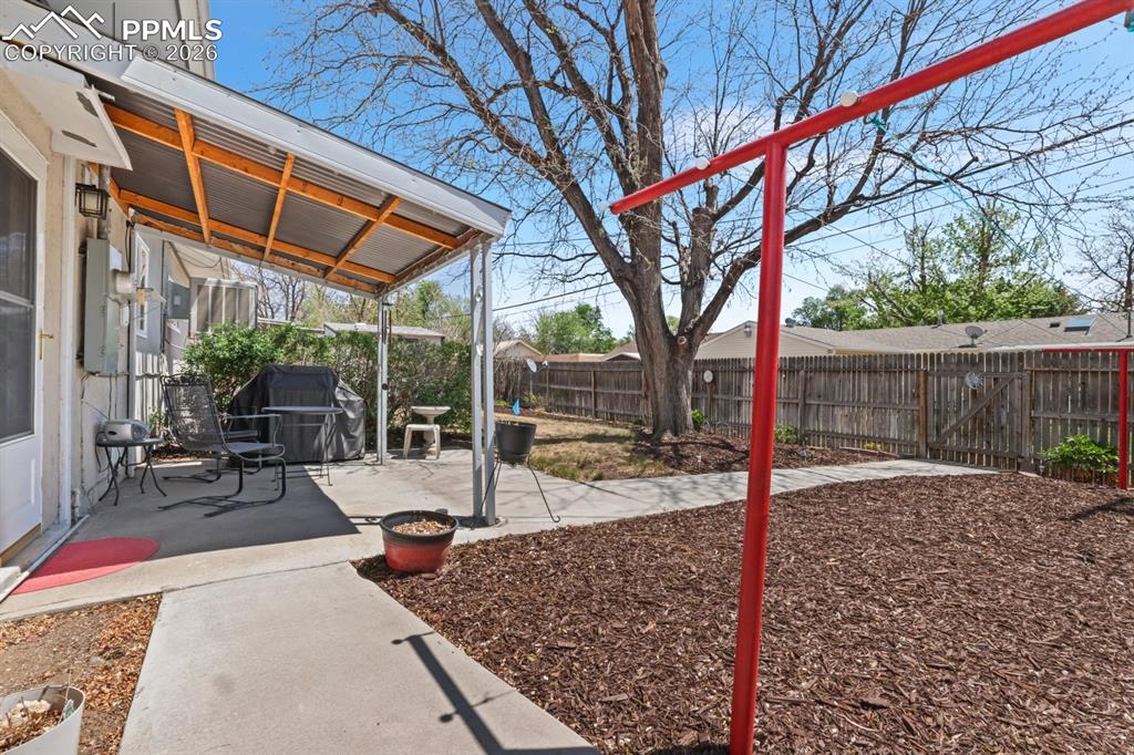 Image 23 of 27: Covered back patio for weekend BBQs and relaxation.