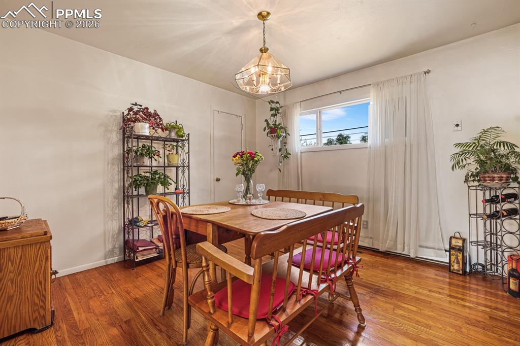 Image 7 of 27: Formal Dining Room with hardwood floors, an attractive light fixture, and c