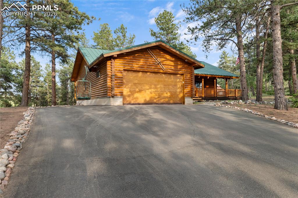 Image 1 of 45: View of front of home featuring an attached garage, driveway, a metal roof,
