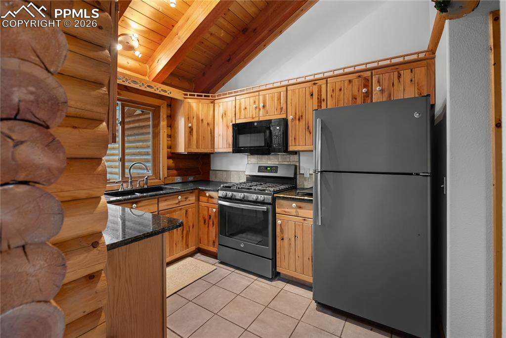 Image 16 of 45: Kitchen with freestanding refrigerator, stainless steel range with gas cook