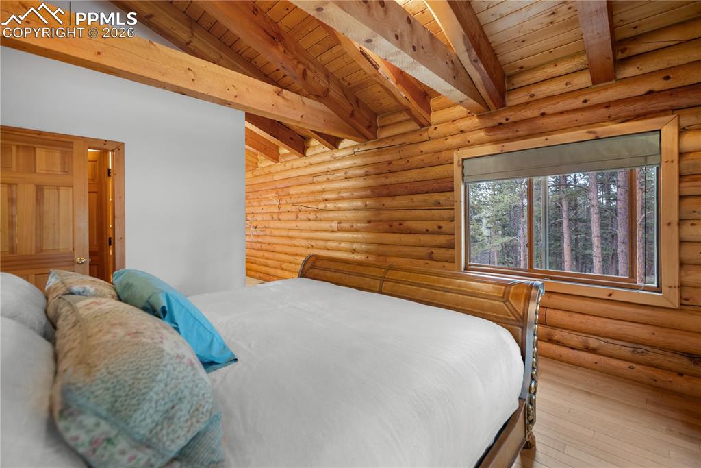 Image 22 of 45: Bedroom featuring a wood ceiling with exposed beams, wood-type flooring, an