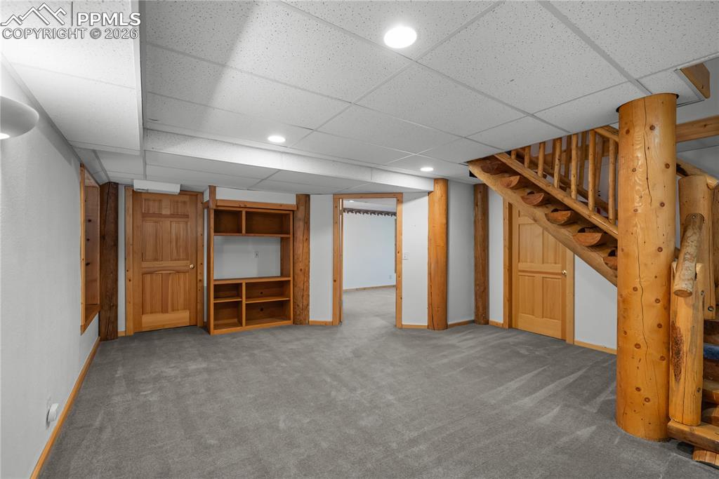 Image 29 of 45: Finished below grade area with carpet floors, stairs, a drop ceiling, and r