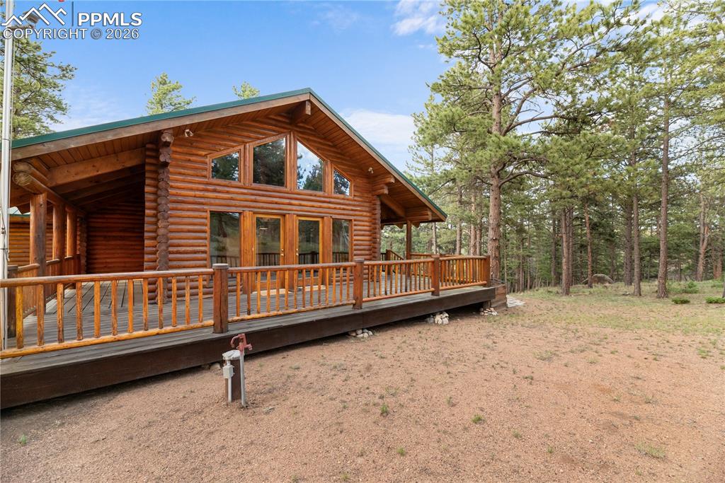 Image 4 of 45: Back of property with log exterior and a deck