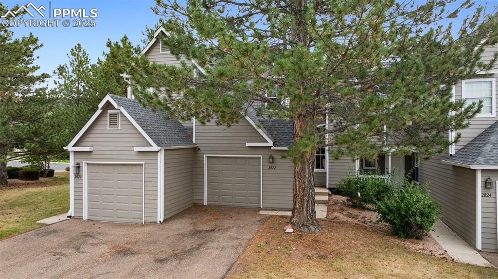 Image 2 of 48: Obstructed view of property with roof with shingles, a garage, and asphalt 