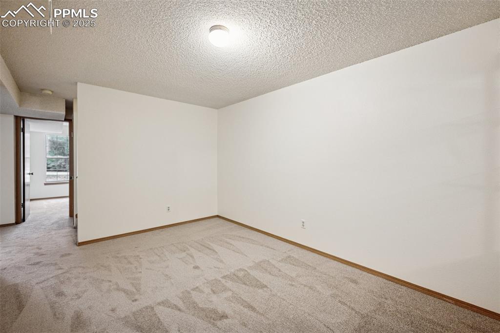 Image 23 of 48: room with light carpet and a textured ceiling