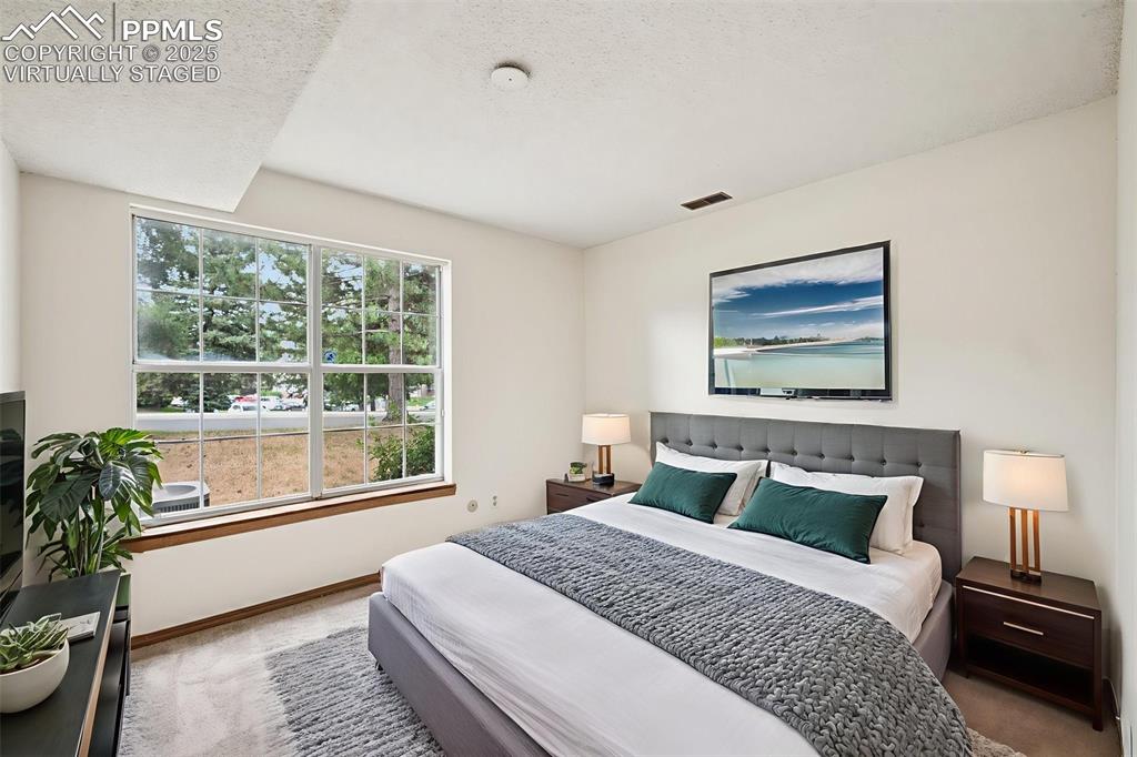 Image 24 of 48: virtually staged - Bedroom featuring carpet flooring and a textured ceiling