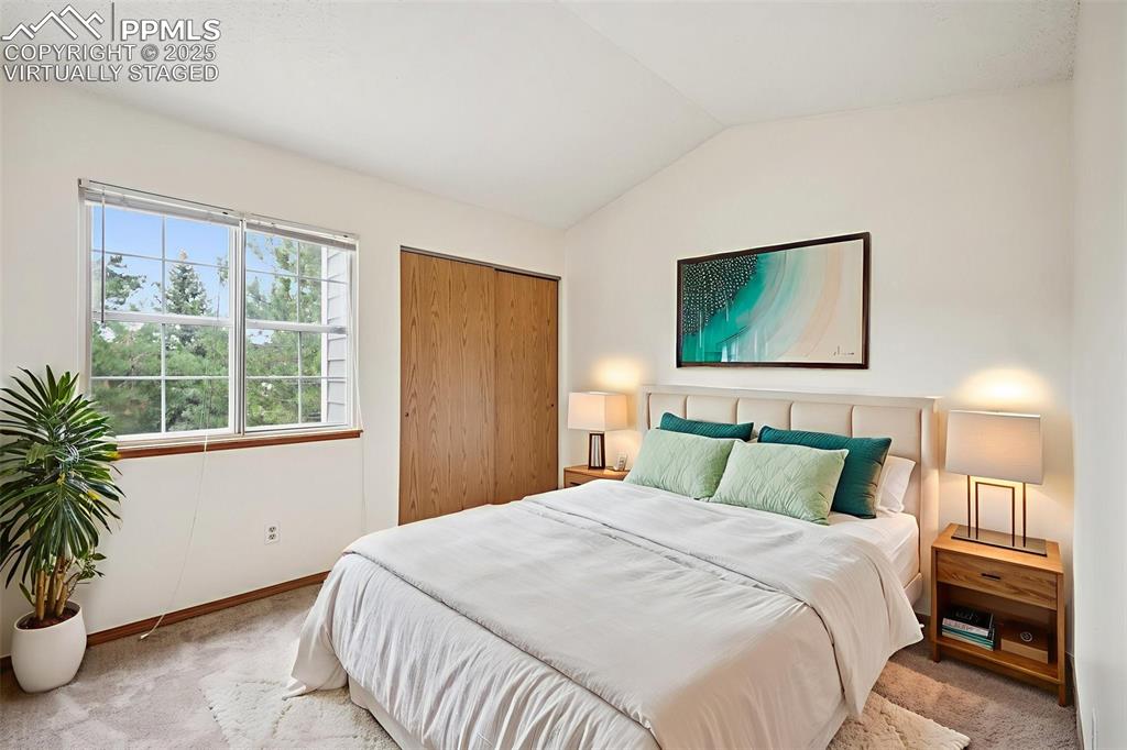 Image 25 of 48: virtually staged - Bedroom with carpet, vaulted ceiling, and a closet