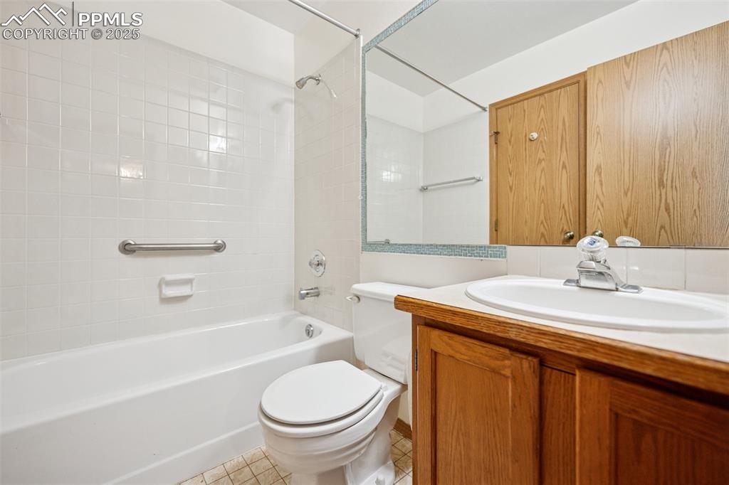 Image 31 of 48: Bathroom featuring bathing tub / shower combination, vanity, and tile patte