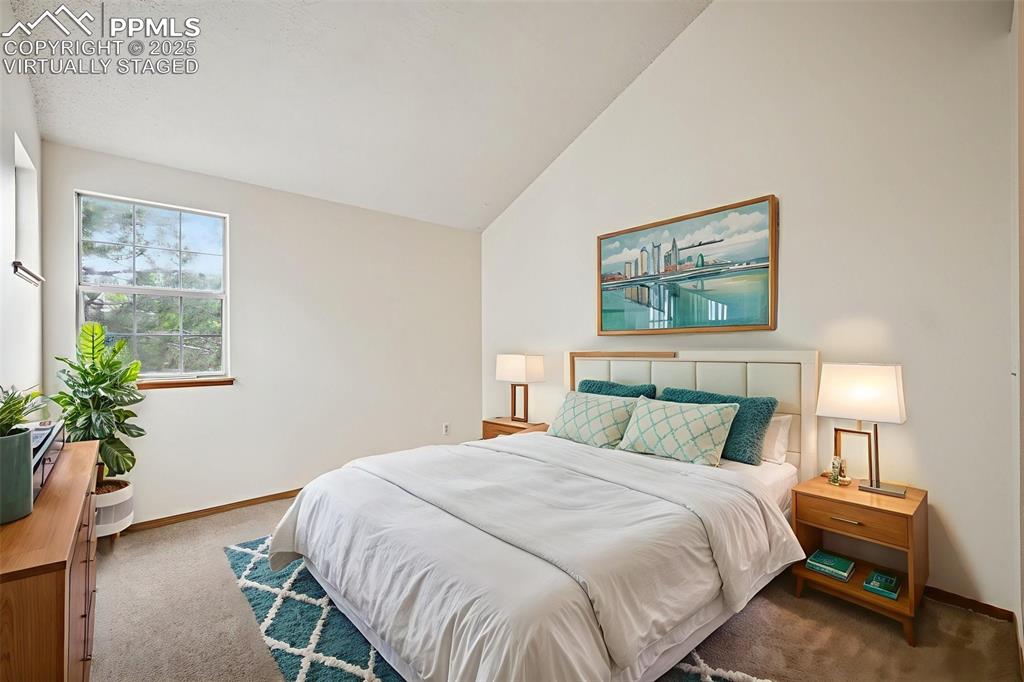 Image 34 of 48: virtually staged - Carpeted bedroom with vaulted ceiling and baseboards