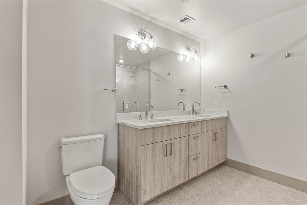 Image 8 of 22: Generously sized bathroom features double vanity with quartz top