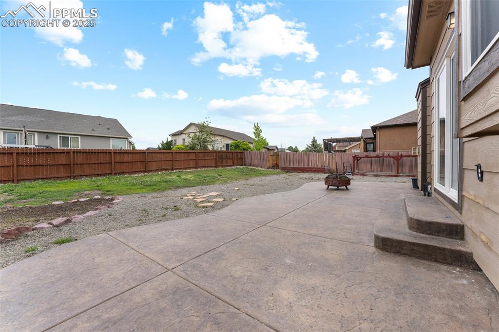 Image 12 of 50: Backyard includes Stamped Concrete Patio, Dedicated Dog Run , Garden Bed Ar
