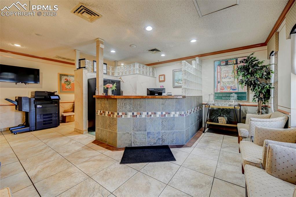 Image 10 of 45: Welcome area featuring crown molding, recessed lighting