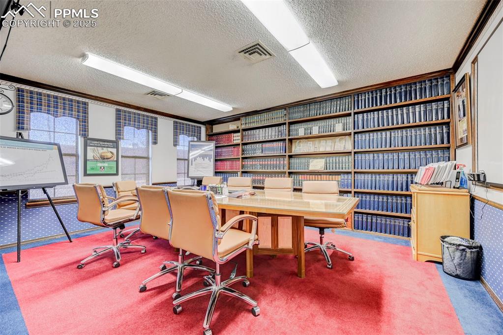 Image 13 of 45: Carpeted office space featuring a textured ceiling and ornamental molding