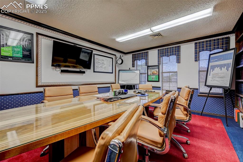 Image 14 of 45: Office with crown molding, a textured ceiling, and carpet flooring