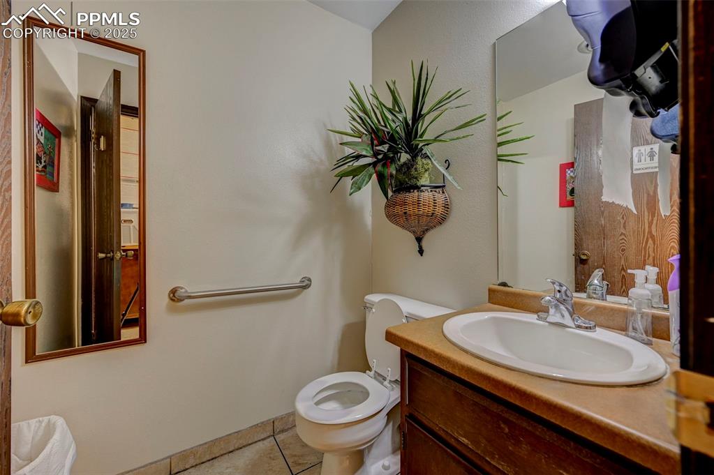 Image 19 of 45: Bathroom with toilet, tile patterned floors, and vanity