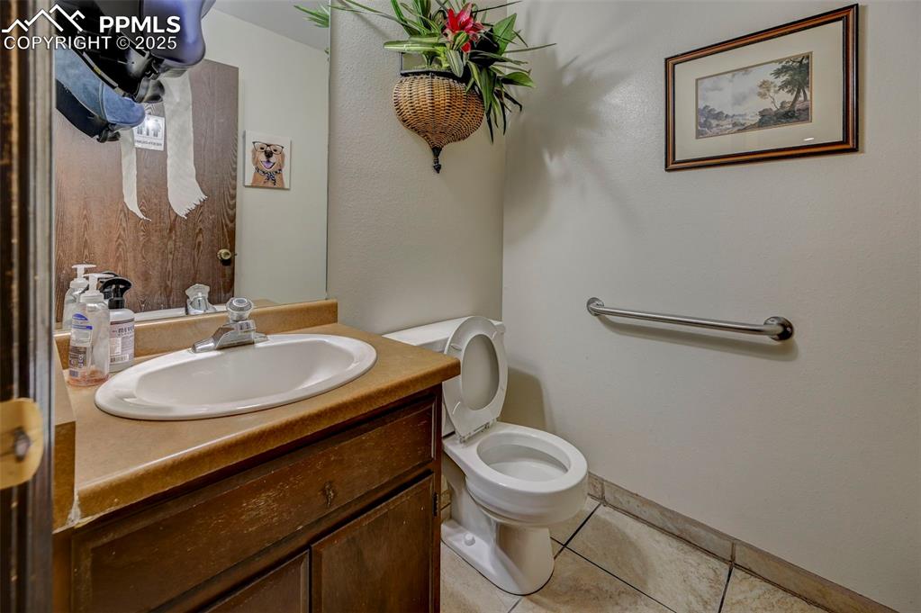 Image 20 of 45: Half bath featuring tile patterned floors, vanity, and toilet