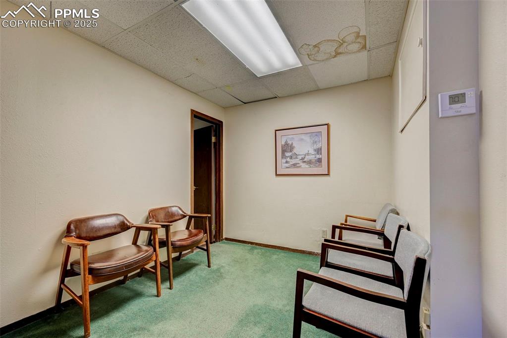Image 31 of 45: Sitting room featuring a drop ceiling and carpet flooring