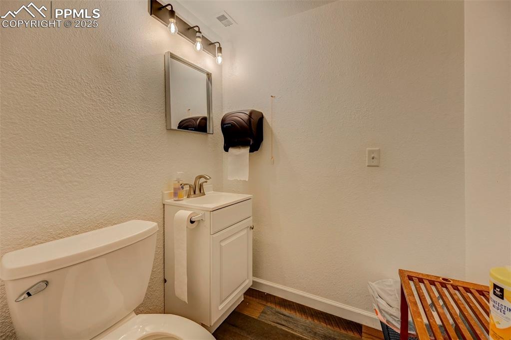 Image 33 of 45: Bathroom with vanity, toilet, wood finished floors, and baseboards