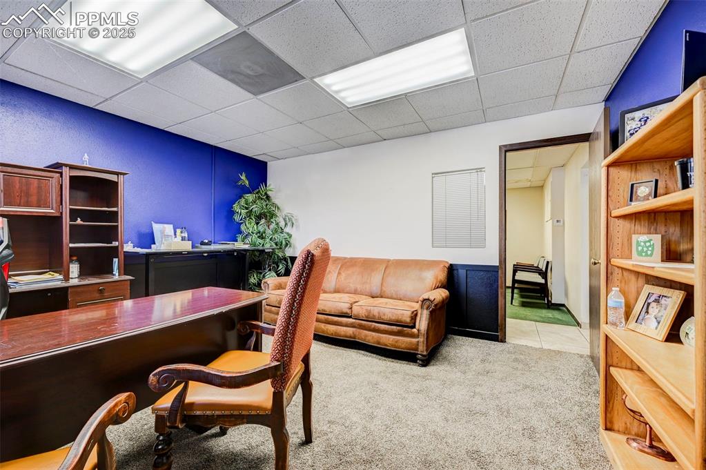 Image 36 of 45: Office with a paneled ceiling and carpet