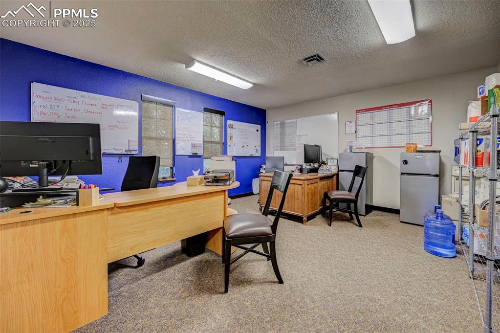 Image 40 of 45: Office area featuring carpet floors and a textured ceiling