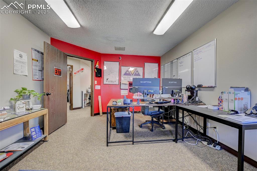 Image 43 of 45: Office space featuring a textured ceiling and carpet