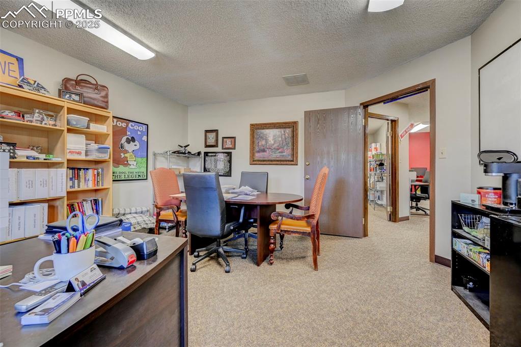 Image 45 of 45: Home office with light colored carpet and a textured ceiling