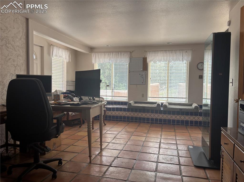 Image 14 of 25: Office area featuring a textured ceiling and healthy amount of natural ligh