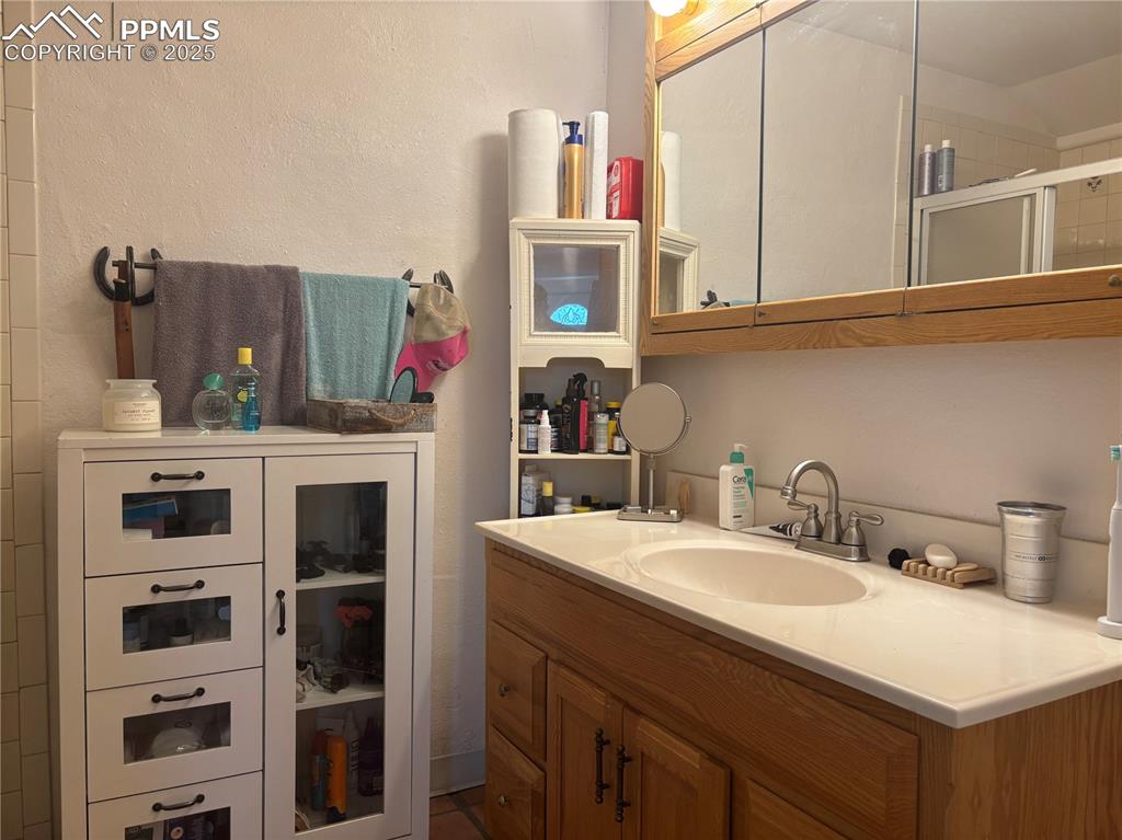 Image 16 of 25: Full bathroom with vanity and a shower stall